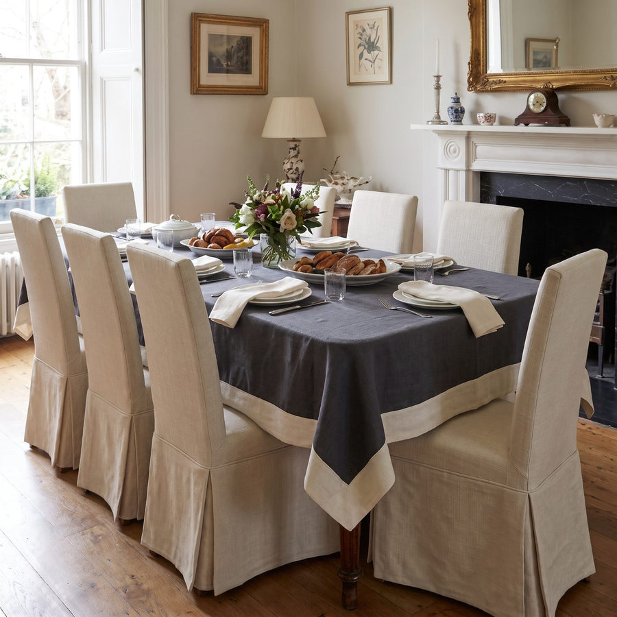 Charcoal linen tablecloth with cream border in an elegant dining room